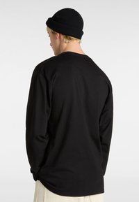 Schwarzes Langarmshirt aus Baumwolle mit rundem Halsausschnitt und entspannter Passform. Eine einfarbige Bluse ohne Muster oder sichtbare Akzente.