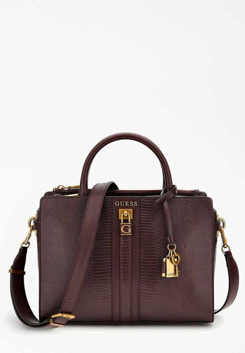 Tumma burgundin värinen käsilaukku, jossa on teksturoitu pinta ja kultaiset yksityiskohdat. Varustettu yläkahvoilla, irrotettavalla olkahihnalla ja riippulukko yksityiskohtana.