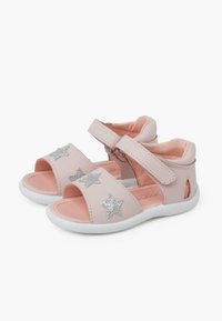 Růžové sandály s hladkým koženým povrchem, s stříbrnými hvězdnými akcenty, otevřeným designem, nastavitelným popruhem a strukturovanou bílou podrážkou.