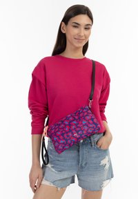 Borsa a tracolla con motivo leopardato blu e rosa, realizzata in tessuto resistente, dotata di una tracolla nera e di una chiusura con zip.