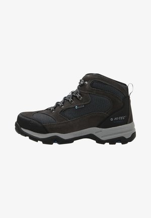 Donkergrijze en zwarte middelhoge wandelschoen met meshpanelen, metalen veterogen, robuust zool en gebrande "Hi-Tec Waterproof" op de hiel.