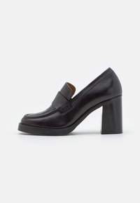 Black leather high-heeled loafers with a round toe, thick block heel, and a stitched accent strap over the vamp. Smooth texture.