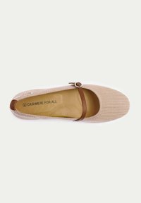 Beige kashmirballettskor med ribbad textur, rund tå och ett brunt band med en silverfärgad cirkulär spänne. Inre logotyp synlig.