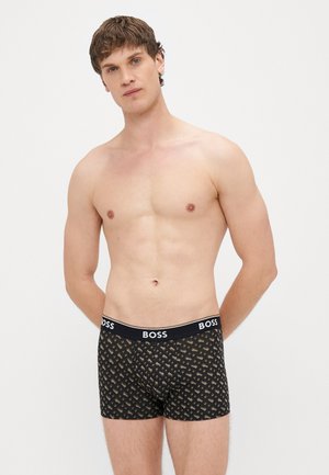 Boxers pretos com padrão geométrico, feitos de tecido macio, com uma faixa de logotipo na cintura e design ajustado.