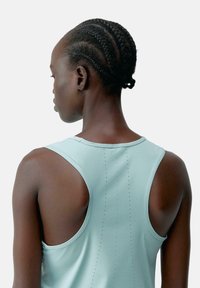Lichtblauw sporttanktop met een racerback ontwerp, met een gladde textuur en geperforeerde details langs de achternaad.