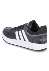 Sneaker nera con strisce bianche, tomaia in sintetico, punta rotonda, dettagli testurizzati, colletto imbottito e suola in gomma con un motivo di battistrada distintivo.