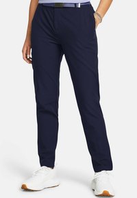 Marineblå bukser lavet af letvægtsstof med en tapered design, med sidelommer og et diskret elastisk taljebånd for komfort.