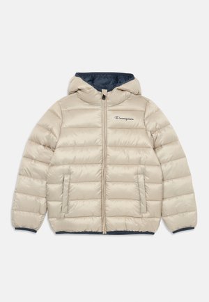 Veste rembourrée beige avec une capuche marine, fermeture éclair, deux poches avant et un logo Champion brodé sur la poitrine gauche.