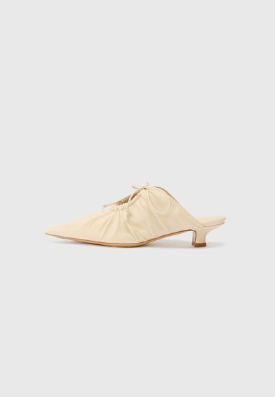 Crème-kleurige leren instap schoenen met een spitse neus, geplooide details aan de voorkant en een korte blokhak.