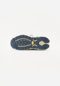 Trail running shoe sole featuring a rugged blue tread pattern, beige midsole, and a textured design for enhanced grip and stability.