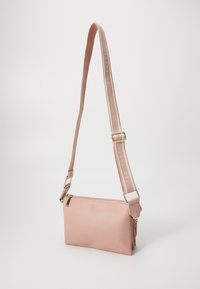 Borsa a tracolla in pelle rosa con chiusura con zip, cinturino regolabile con testo "TED BAKER" e dettagli in oro.