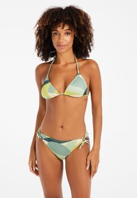 Bikini komplektas su trikampio formos viršumi, kuris turi reguliuojamus raiščius. Medžiaga rodo geometrinį raštą žalias, mėlynas ir kremiškas atspalvius.