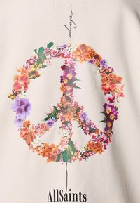 Sudadera de algodón con un gráfico de símbolo de paz floral colorido, que presenta una variedad de flores en tonos de púrpura, naranja y blanco. El texto debajo dice "AllSaints."