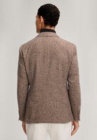 Bruine en zwarte geruite blazer van een gestructureerde stof, met een notch-kraag en knoopmanchetten, gezien vanuit de achterkant.