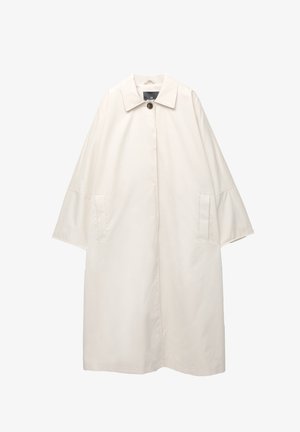 Kevyt, kermaisen värinen takki, jossa on leveä, rakenteellinen kaulus, kolmen neljänneksen hihat ja kaksi etutaskua. Napitus kaulassa.