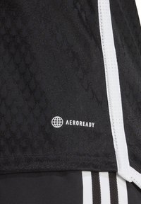 Tessuto performante nero con un motivo testurizzato, accenti bianchi e un logo "AEROREADY" bianco sul lato.