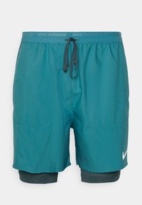 Tealfärgade löpshorts med elastisk midja, ytterlager och ett innerlager som är tight. Har två sidofickor och en liten vit Nike-logotyp.