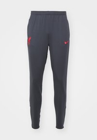 Tmavě šedé sportovní kalhoty s červeným emblémem Liverpool FC na levém stehně a červeným logem Nike na pravém stehně, elastický pas.