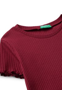 Burgundská proužkovaná krátkosrstá halenka s kulatým výstřihem a volánkovými manžetami. Obsahuje zelenou etiketu s nápisem "United Colors of Benetton."