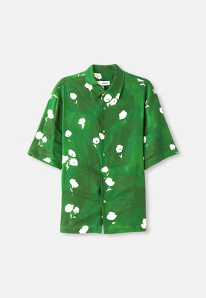 Short-sleeve button-up shirt in green fabric with white floral print, featuring a camp collar and relaxed fit. Textured, lightweight material.