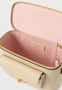 Beżowa skórzana torba o fakturowanej powierzchni, z złotym zamkiem błyskawicznym i różowym wnętrzem. Posiada klapkę zamykającą oraz wewnętrzną metkę z logo.