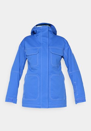 Plava vodootporna jakna s visokim ovratnikom, dva velika prednja džepa i džepom na rukavu sa zatvaračem. Ima kontrastne bijele šavove.