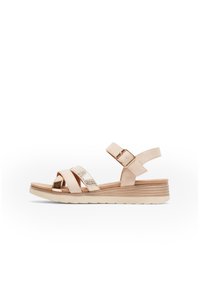 Sandale beige avec des brides croisées, accent à motif serpent en faux cuir, fermeture par boucle réglable et semelle en wedge légère et texturée.