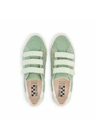 Baskets en daim vert avec trois bandes auto-agrippantes texturées, présentant un motif crocodile et une semelle en caoutchouc. L'étiquette indique "NO NAME."