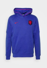 Felpa Nike blu con tasca a marsupio, cappuccio con cordoncino e logo leone ricamato in nero. Presenta accenti rossi sul logo e sul colletto.