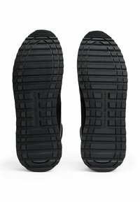 Schwarze Gummisohlen mit tiefem, gerilltem Profil und geprägten Details für Grip und Langlebigkeit. Glatte Kanten und abgerundetes Zehendesign.