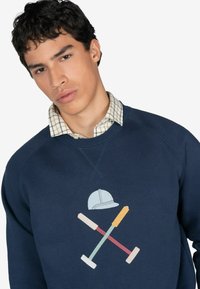 Marineblå sweatshirt med rund hals, der har farverige broderede værktøjer og et hjelmdesign på forsiden. Tekstureret stof.