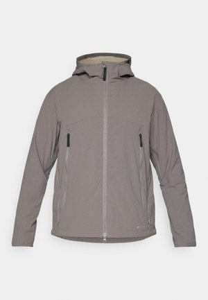 Giacca grigia con cappuccio, chiusura a zip frontale, due tasche con zip e un morbido rivestimento in pile. Presenta un design snello e una texture liscia.