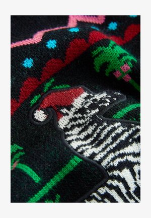 Sweter dzianinowy ma czarną podstawę z kolorowymi wzorami geometrycznymi, w tym czerwonym, zielonym i niebieskim. Wyjątkowy wzór zebry w białym i czarnym.