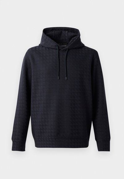 Črna kapuca s teksturiranim, prešitim vzorcem, z vrvico za zatezanje in rebrastimi manšetami, ki nudi sproščen fit in mehak material.