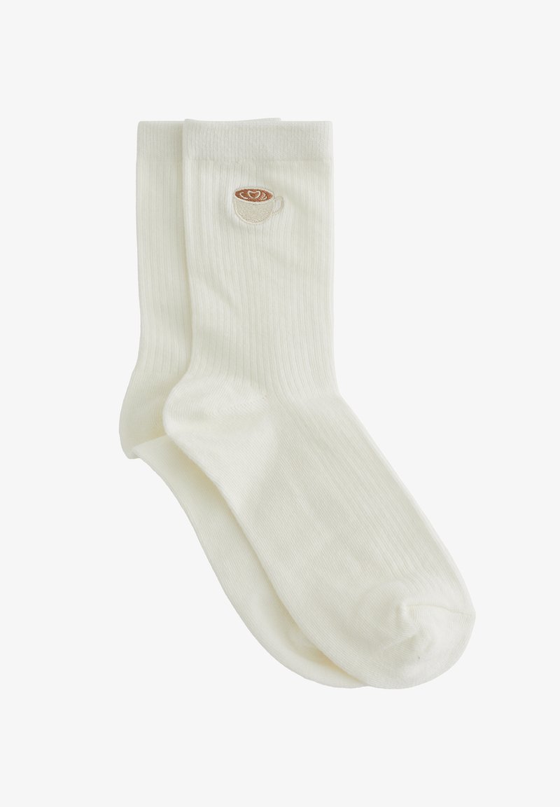 Chaussettes blanches côtelées mi-mollet avec une petite tasse de café brodée et un art latte en forme de cœur sur le côté près du bord-côte.