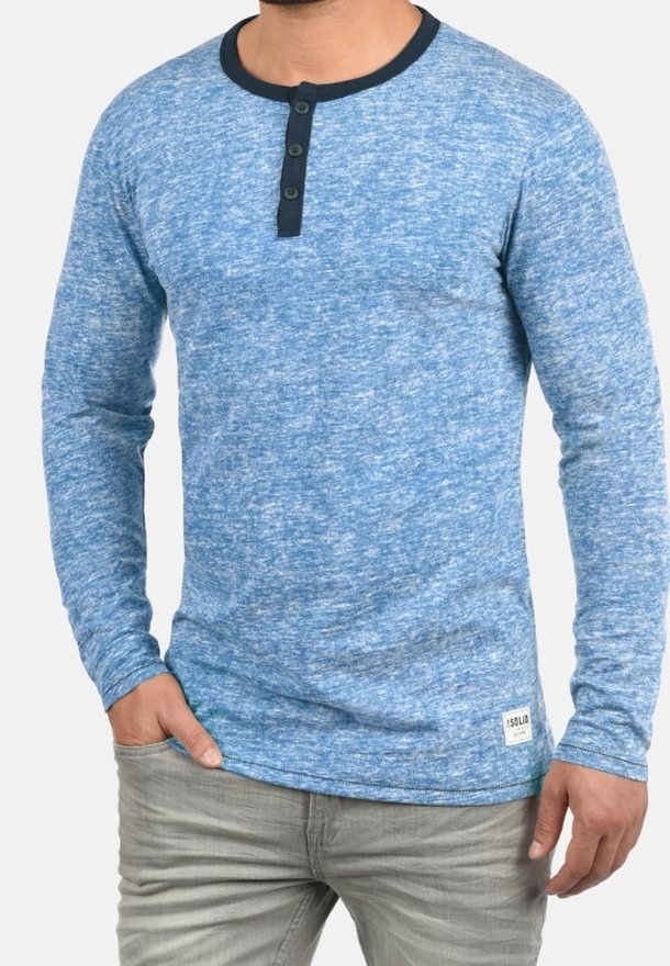 Chemise à manches longues en bleu mélangé avec un col rond, patte de boutonnage à trois boutons, et finition bleu foncé ; tissu texturé près de l'ourlet affichant l'étiquette de la marque.