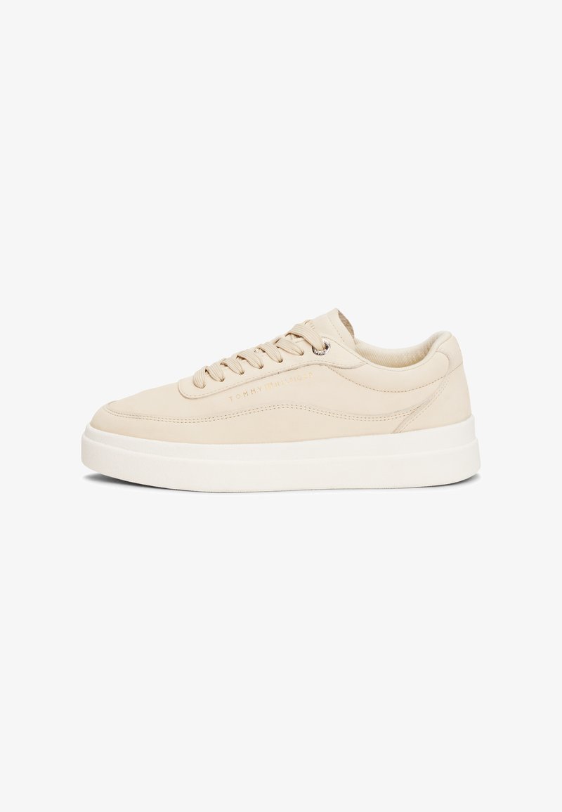 Beige Leder Sneaker mit runder Zehenpartie, flacher weißer Sohle, Schnürung an der Vorderseite und geprägtem Markenlogo an der Seite. Glatte Textur, minimalistisches Design.