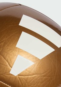 Ruskea urheilupallo, jossa on kiiltävä pinta ja valkoisia geometrisia kuvioita koko pinnalla. Sauman yksityiskohdat näkyvissä yläosassa.