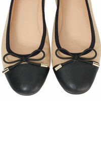 Ballet flats met een beige suède bovenwerk, zwarte leren punt, zwarte afwerking en een strikdetail met gouden accenten.