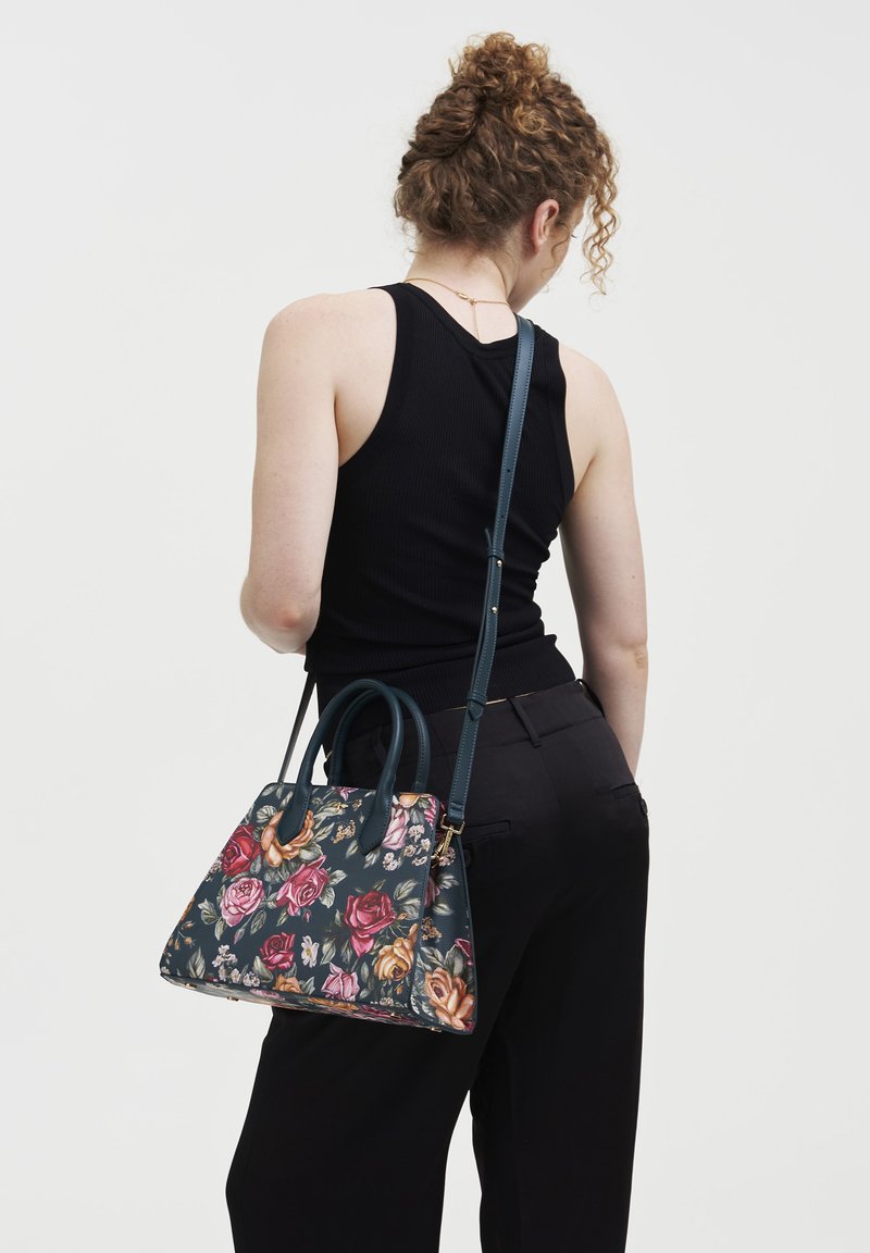 Borsa floreale con base verde scuro, decorata con rose rosa e gialle. Ha due manici e una tracolla rimovibile.