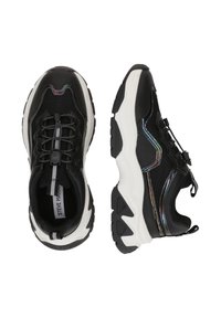 Sneaker sportive nere con tomaia in mesh e sintetico. Presentano un design senza lacci, dettagli riflettenti e una suola bianca spessa.