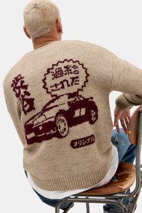 Strikkegenser i beige med burgunder bilgrafikk og japansk tekst på ryggen. Har ribbet kant og mansjetter, avslappet passform.