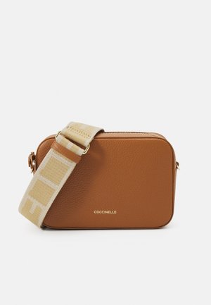 Brun læder rektangulær crossbody taske med beige justerbar stofrem og guldfarvet lynlås på toppen, lille guld Coccinelle logo foran.