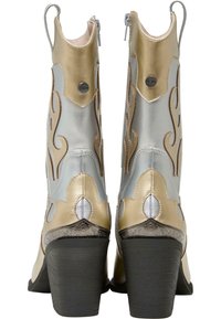 Cowgirl stövlar med en metallisk silver- och gulddesign, flammmönster, en svart kraftig klack och dragkedjor för stängning.