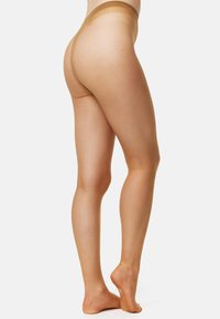 Tanga nude con una textura suave y translúcida. Presenta un diseño de talle bajo, una cintura delgada y una cobertura trasera mínima.