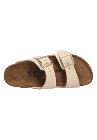 Beige sandal with two adjustable straps, silver buckles, cork footbed, and suede-like insole texture. Designed for comfort and durability.