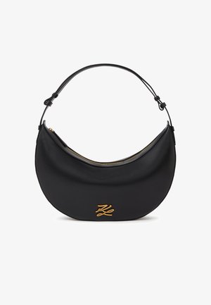 Črna usnjena torbica v obliki polmeseca z nastavljivim trakom, zlatim zadrgo in zlatim stiliziranim monogramom na sprednji strani.