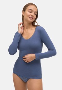 Camiseta térmica de manga larga, azul, con escote redondeado, ribete de encaje y un diseño ajustado, combinada con unas braguitas a juego con un estampado floral.