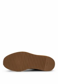 Suola di scarpa in gomma marrone con righe orizzontali e area del tallone testurizzata, con il marchio "HUGO" vicino al tallone.