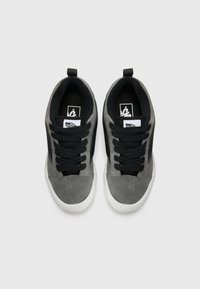 Gray suede sneakers with black accents, flat laces, and a white rubber sole. Features a logo on the tongue and a pull tab at the heel.